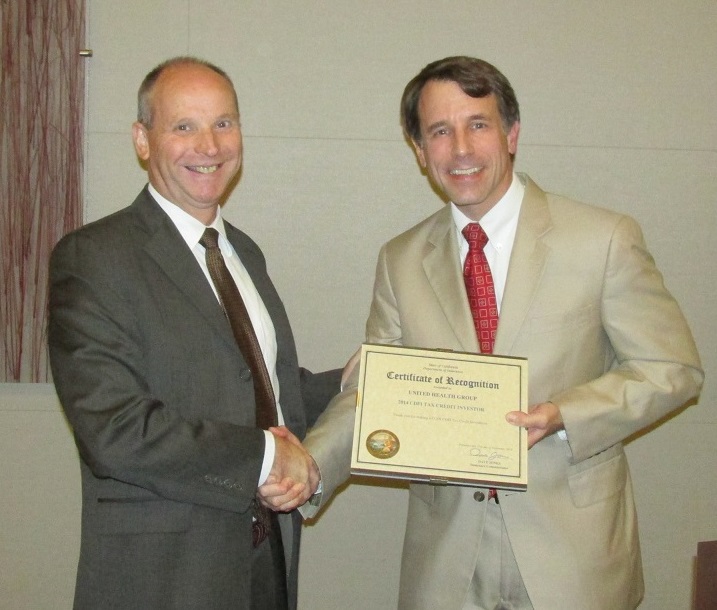 Steven Henry, on behalf of UnitedHealthcare, accepting a COIN CDFI Tax Credit Award from the Commissioner.