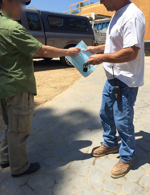 CDI investigator handing out educational materials to contractor