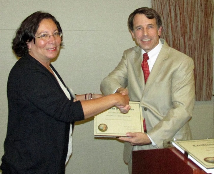 Diane Giampaoli, on behalf of CSAA, accepting a COIN CDFI Tax Credit Award from the Commissioner.
